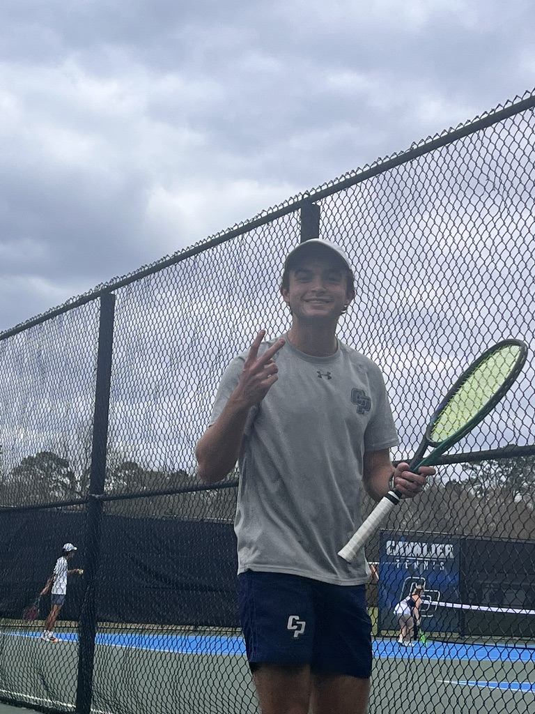 Donovan Burke holding a tennis racket on a tennis court